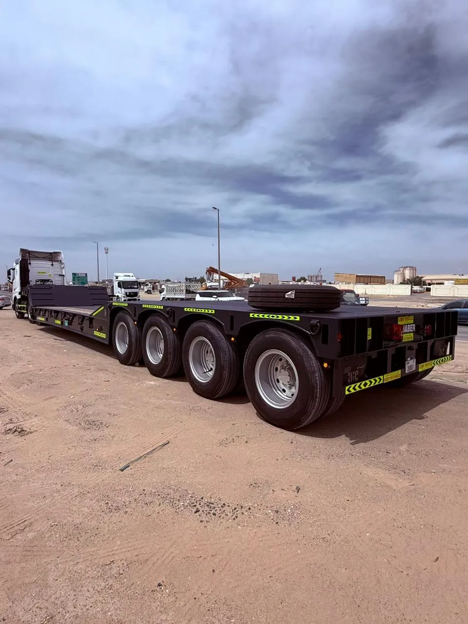 Brand-new black 4-axle Al Jaber low-bed trailer staged in the yard