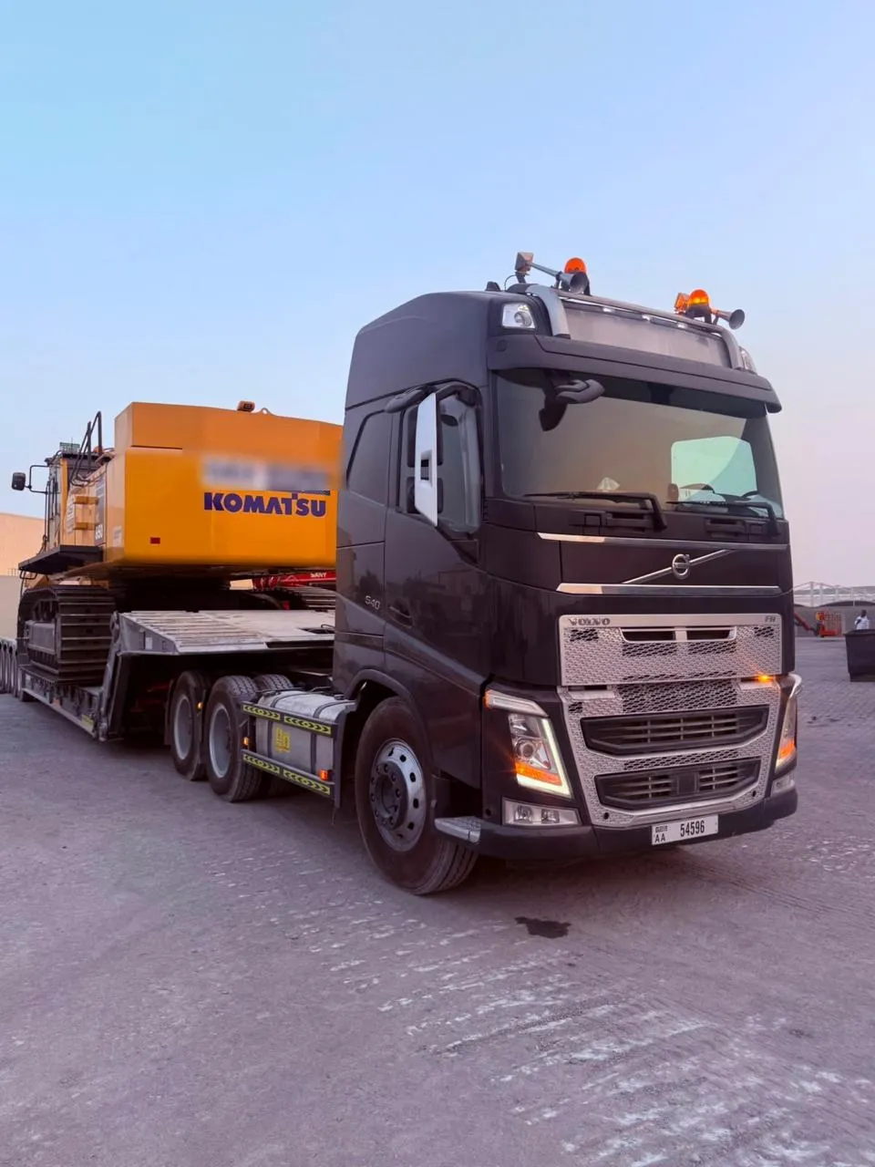 Volvo FH 540 prime mover coupled to a lowbed trailer carrying a Komatsu excavator