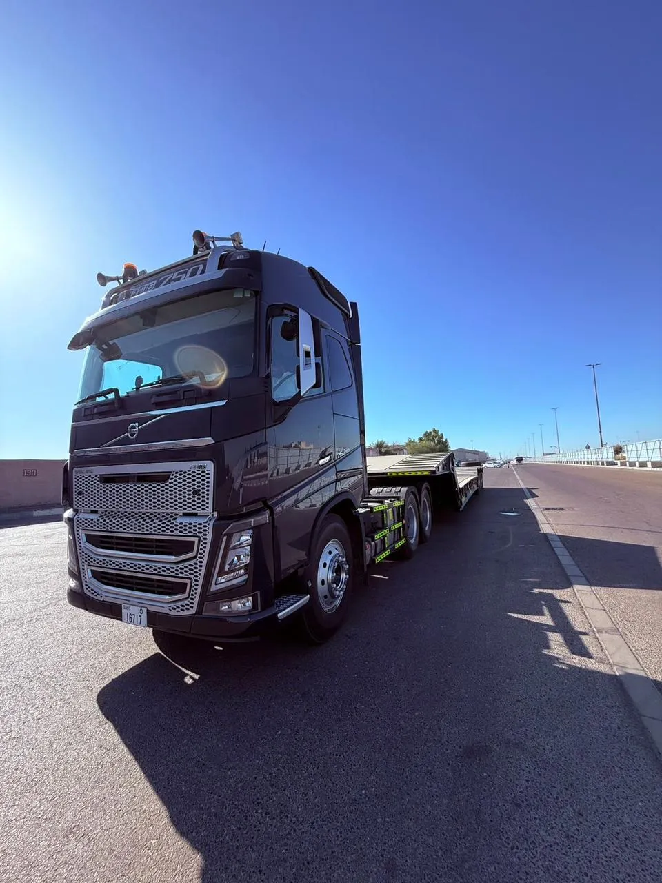 Black Volvo FH16 750 prime mover coupled to a hydraulic low-bed trailer on a UAE road